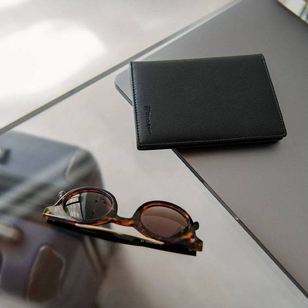 passport cover and sunglasses on glass table