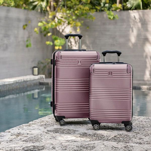 two pink travelpro suitcases standing next to each other in front of a pool